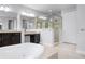 Bathroom featuring dual vanities, a soaking tub, and a glass-enclosed shower at 1719 Kenilworth St, Sarasota, FL 34231