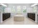Bright bathroom featuring a large soaking tub, double vanities, and plenty of natural light from three windows at 1719 Kenilworth St, Sarasota, FL 34231