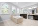 Bathroom with a large soaking tub, dual sinks, lots of natural light, and neutral tile flooring at 1719 Kenilworth St, Sarasota, FL 34231