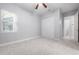 Spacious bedroom with neutral carpet, a ceiling fan, and a view of the outside through a large window at 1719 Kenilworth St, Sarasota, FL 34231