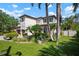 Stately two-story home with lush landscaping, including palms and manicured lawn, under a partly cloudy sky at 1719 Kenilworth St, Sarasota, FL 34231