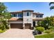 Stately two-story home with a three-car garage, tile roof, lush landscaping, and a brick paved driveway at 1719 Kenilworth St, Sarasota, FL 34231