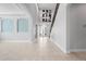 Bright foyer with a staircase, wrought iron railing, neutral colors, tiled floors, and a vaulted ceiling at 1719 Kenilworth St, Sarasota, FL 34231