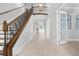 Elegant foyer with a staircase, wrought iron railing, neutral colors, tiled floors, and a vaulted ceiling at 1719 Kenilworth St, Sarasota, FL 34231