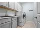 Modern laundry room with white cabinets, countertops, and a stacked washer and dryer set at 1719 Kenilworth St, Sarasota, FL 34231