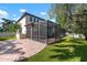 Backyard featuring a screened pool enclosure, patio, and lush green lawn with a brick walkway at 1719 Kenilworth St, Sarasota, FL 34231