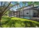 Backyard view of a screened-in pool and patio area, with lush green landscaping at 1719 Kenilworth St, Sarasota, FL 34231