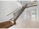 Elegant staircase with wrought iron railing, neutral colors, tiled floors, and wood steps at 1719 Kenilworth St, Sarasota, FL 34231
