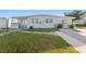 Inviting single-story home featuring a well-maintained lawn, and a clean, painted exterior in a lovely neighborhood at 221 Duxbury Ave, Port Charlotte, FL 33952