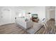 Bright living room with stylish wood flooring, a cozy white sofa, and a decorative brick wall with modern decor at 221 Duxbury Ave, Port Charlotte, FL 33952