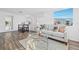 Inviting living area with new wood floors, a comfortable sofa, and ample natural light from the large windows at 221 Duxbury Ave, Port Charlotte, FL 33952