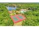 A beautiful aerial view showcasing the tennis courts, playground, and lake, with stunning green landscaping at 251 Dove Trl, Bradenton, FL 34212