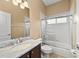Bright bathroom featuring granite counters, a tub-shower combo with glass doors, and tiled floors at 251 Dove Trl, Bradenton, FL 34212