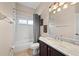 Traditional bathroom with shower-tub combo, white tiles, and vanity with light marble countertop at 251 Dove Trl, Bradenton, FL 34212