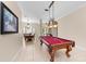 Game room with pool table, chandelier and open views of the dining room and entry at 251 Dove Trl, Bradenton, FL 34212