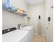 Practical laundry room with washer, dryer, shelving, and ironing board, offering convenience and organization at 251 Dove Trl, Bradenton, FL 34212