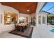 Outdoor dining space with travertine tile, wood ceilings and views into the pool and main living area at 251 Dove Trl, Bradenton, FL 34212