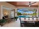 Inviting outdoor living space with a dining area that overlooks a screened-in pool and lake views at 251 Dove Trl, Bradenton, FL 34212