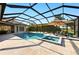 Beautiful pool and spa with sun umbrella and chairs inside screened lanai at 251 Dove Trl, Bradenton, FL 34212