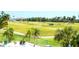 Scenic view of the golf course featuring lush green fairways, palm trees, and golfers riding in golf carts at 2608 Waterford Way # B, Palmetto, FL 34221