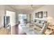 Bright living room with wood floors, comfortable seating, ceiling fan, and sliding glass doors leading to a covered patio at 2608 Waterford Way # B, Palmetto, FL 34221