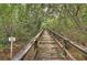 Wooden boardwalk through a lush, green, shaded wetland conservation area with a sign at 2608 Waterford Way # B, Palmetto, FL 34221