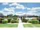 Cambridge Village West Clubhouse featuring manicured landscaping, a walkway, and well-kept lawn at 2614 67Th W St, Bradenton, FL 34209
