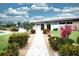 Cambridge Village West Clubhouse with vibrant landscaping, a walkway, and manicured bushes at 2614 67Th W St, Bradenton, FL 34209