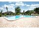 Sparkling community pool surrounded by brick patio, tables, lounge chairs, and lush landscaping at 2614 67Th W St, Bradenton, FL 34209