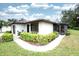 A single-story home showcasing a cozy screened-in lanai, a well-maintained yard, and beautiful landscaping at 2614 67Th W St, Bradenton, FL 34209