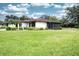 This home features a screened-in lanai, mature landscaping, and a spacious backyard with lush green grass at 2614 67Th W St, Bradenton, FL 34209