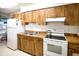 Functional kitchen with essential appliances and wood cabinets, ideal for simple meal preparation at 2614 67Th W St, Bradenton, FL 34209