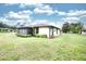 This home features a screened-in lanai, mature landscaping, and a spacious backyard with lush green grass at 2614 67Th W St, Bradenton, FL 34209