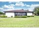 This home features a screened-in lanai, mature landscaping, and a spacious backyard with lush green grass at 2614 67Th W St, Bradenton, FL 34209