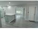 Open-concept kitchen and living area featuring updated flooring, fresh paint, and a kitchen island at 2722 Nancy St, Sarasota, FL 34237