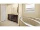 Bright bathroom with double vanity, dark wood cabinetry, and separate soaking tub at 27255 Deep Creek Blvd, Punta Gorda, FL 33983