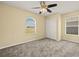 Inviting bedroom with windows, ceiling fan, plush gray carpet, and closet at 27255 Deep Creek Blvd, Punta Gorda, FL 33983