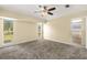 Serene bedroom with plush gray carpet, ceiling fan, and views of the yard at 27255 Deep Creek Blvd, Punta Gorda, FL 33983