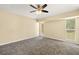 Comfortable bedroom with gray carpet, ceiling fan, and plenty of natural light at 27255 Deep Creek Blvd, Punta Gorda, FL 33983