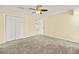 Well-lit bedroom featuring ceiling fan, neutral walls, and access to walk-in closet at 27255 Deep Creek Blvd, Punta Gorda, FL 33983