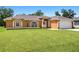 Charming one-story home featuring arched windows, a well-maintained lawn, and a two-car garage at 27255 Deep Creek Blvd, Punta Gorda, FL 33983