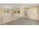 Open-concept living room with tile flooring, ceiling fan, and access to kitchen and outdoor patio at 27255 Deep Creek Blvd, Punta Gorda, FL 33983