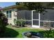 Exterior shot showcasing a screened-in lanai and lush backyard with lawn and plantings at 3312 92Nd E Ave, Parrish, FL 34219