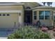 Up close image of a home featuring a two-car garage and vibrant flowers in the landscaped front yard at 3312 92Nd E Ave, Parrish, FL 34219