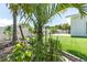Backyard garden bed with vegetable plants surrounded by lush greenery and a white fence at 3417 50Th W St, Bradenton, FL 34209