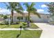Charming single-story home featuring a well-manicured lawn, palm trees, and a white exterior at 3417 50Th W St, Bradenton, FL 34209