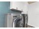 Laundry room showcasing modern stainless steel washer and dryer with blue tile backsplash at 3417 50Th W St, Bradenton, FL 34209