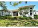 Charming home exterior with manicured landscaping, complemented by lush greenery and a well-maintained lawn at 3870 Alamanda Dr, Sarasota, FL 34238