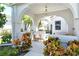 Covered front porch with comfortable seating, potted plants, and charming overhead lighting fixture at 3870 Alamanda Dr, Sarasota, FL 34238