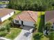 Aerial view of a single-story home with brick paved driveway, well-maintained lawn, and tropical palm trees at 412 Daylily Blvd, Nokomis, FL 34275
